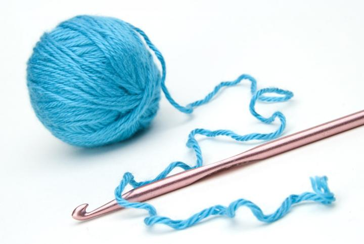 ball of blue yarn with crochet hook