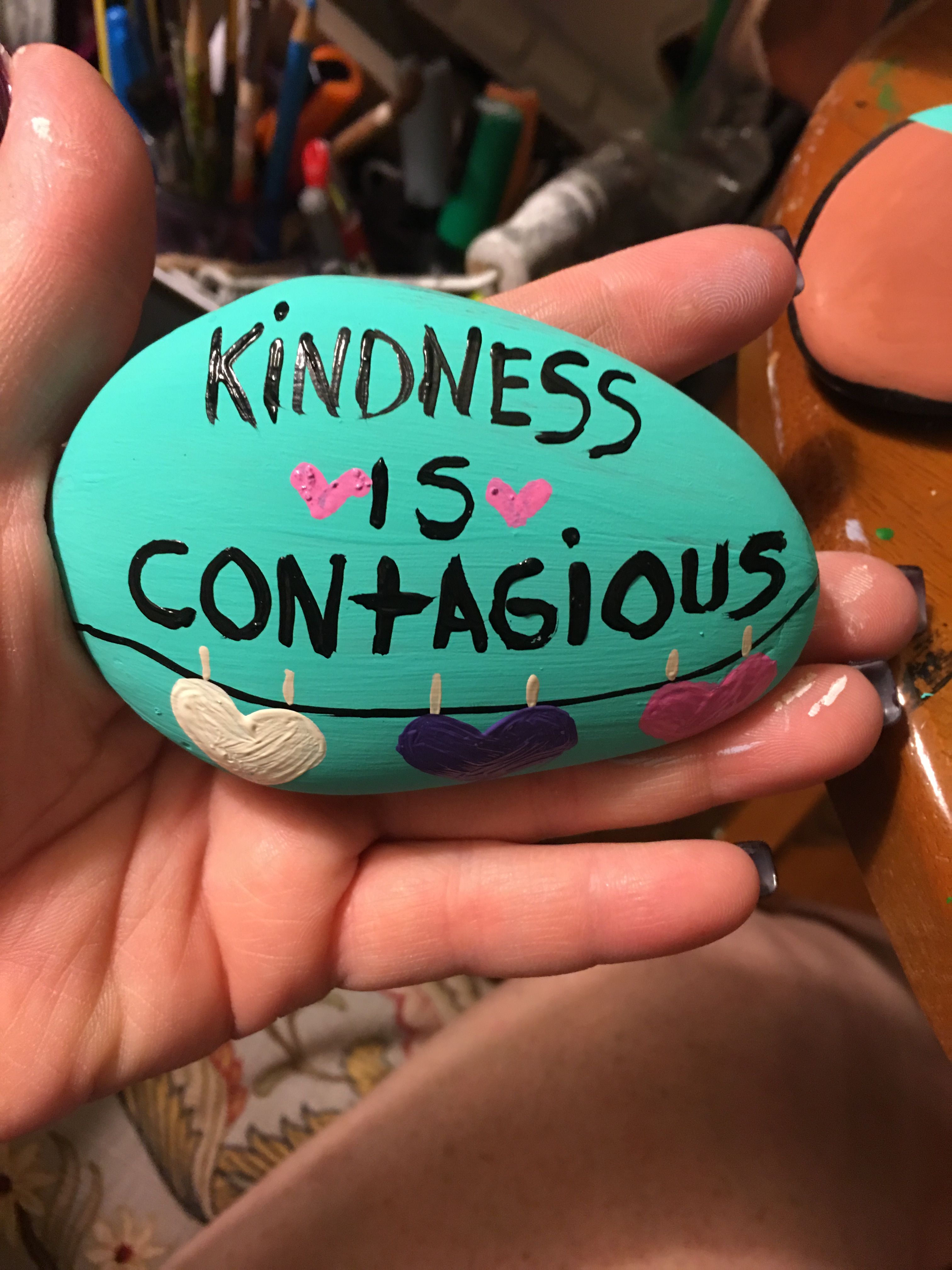 Teal rock with "Kindness is Contagious" written on it