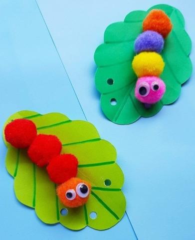 multicolored pom pom caterpillars on green leaves