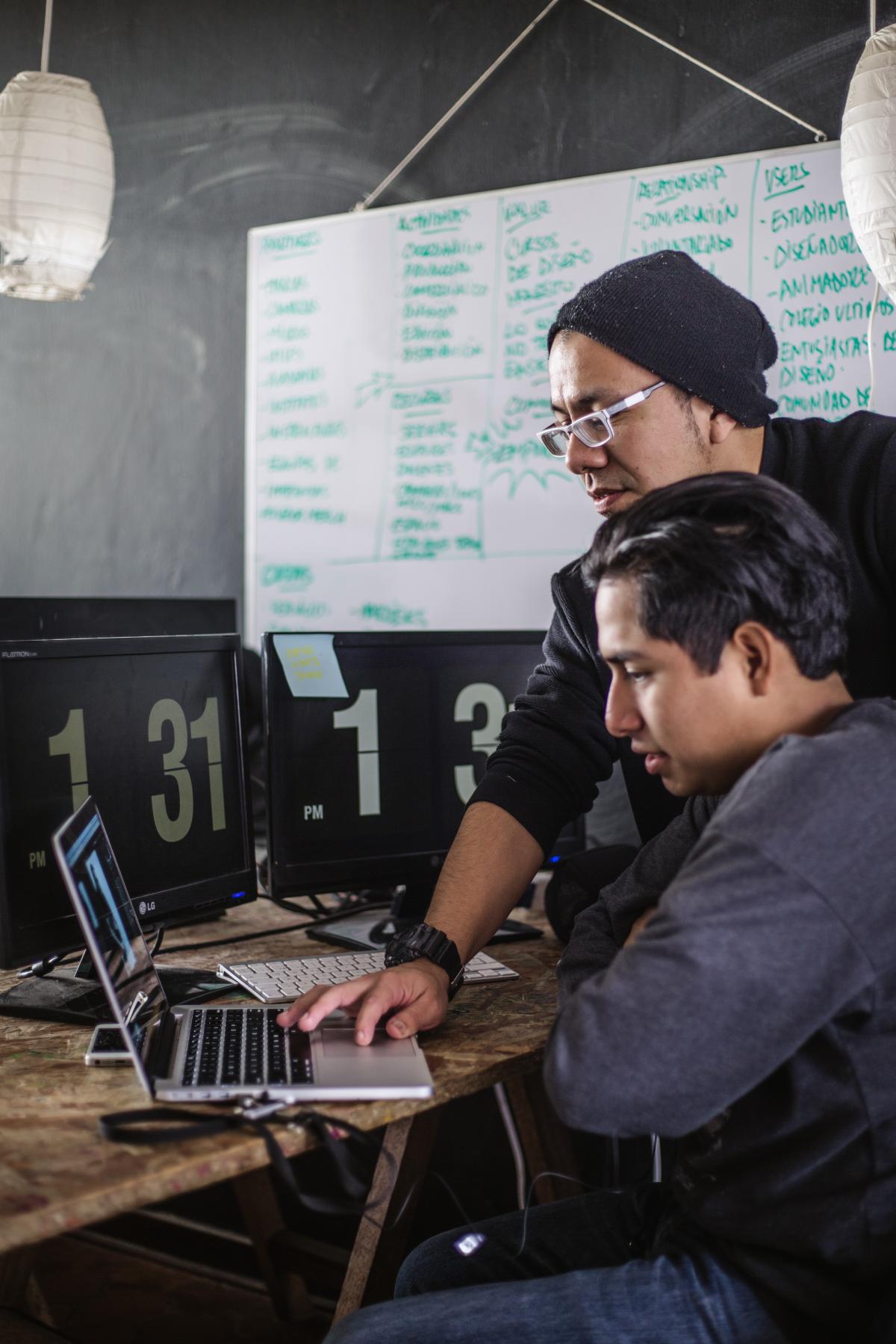 Two people working on a laptop computer