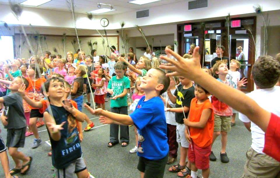 Kids balancing feathers